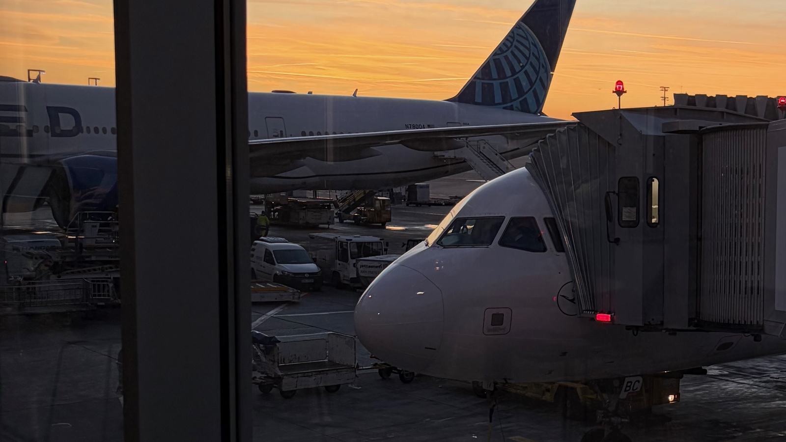 Airplane docket at an airport terminal at sunset, it's getting dark but the sun is still bright enough to create a nice cosy feeling