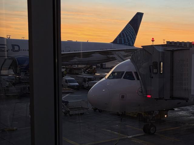 Airplane docket at an airport terminal at sunset, it's getting dark but the sun is still bright enough to create a nice cosy feeling