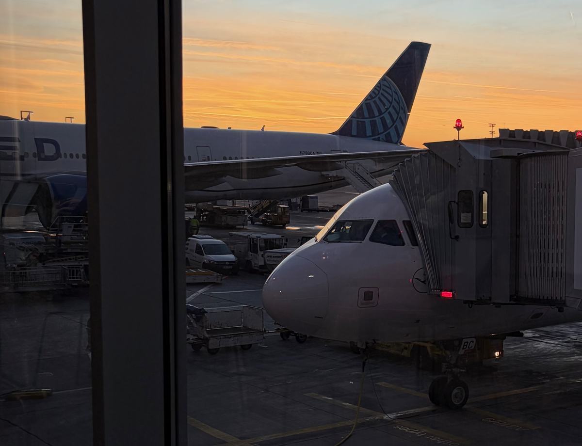 Airplane docket at an airport terminal at sunset, it's getting dark but the sun is still bright enough to create a nice cosy feeling